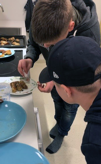 Två elever lägger upp mat på tallrikar