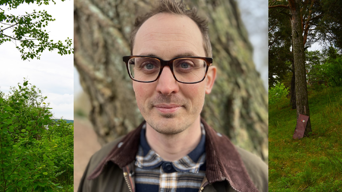 Anders Lindén står utomhus i en skog. Han har rutig skjorta och en brun jacka på sig. 