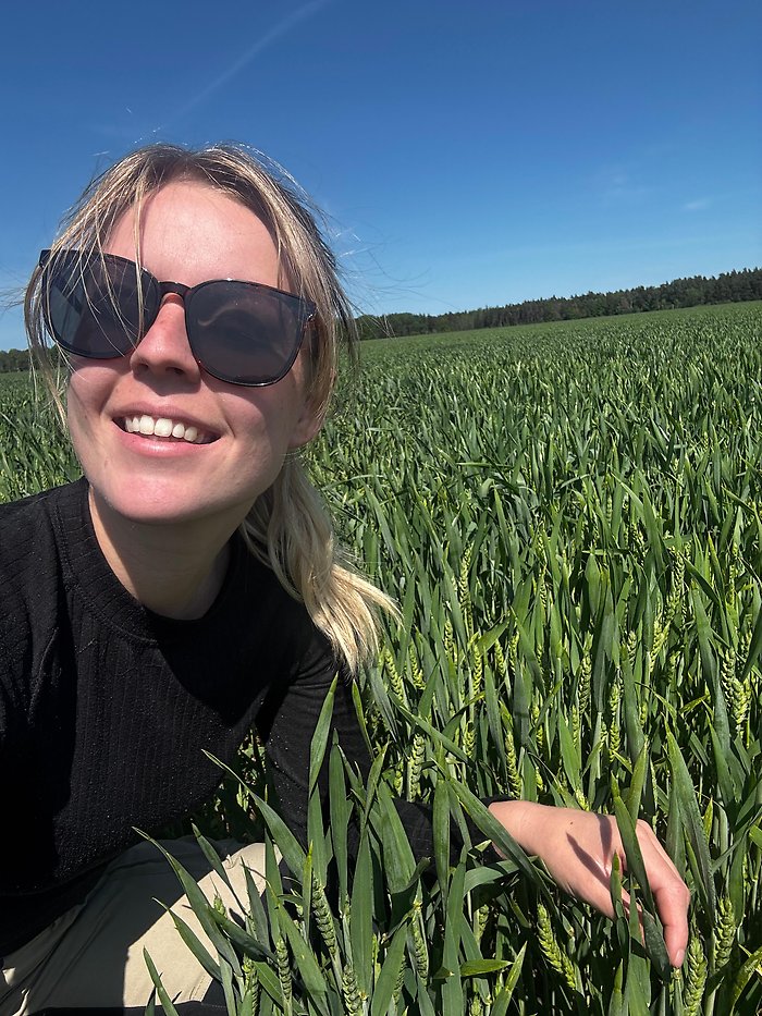 Sara Thungard i svarta solglasögon ute i fält